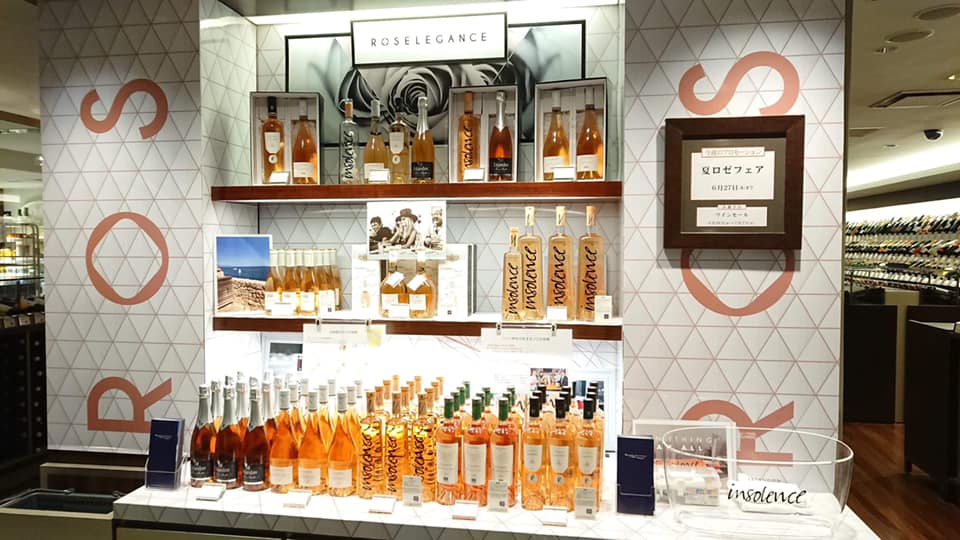 ロゼレガンスの店頭展開写真。大きなロゴや柄を背景に、ロゼワインと販促物が並ぶ売り場。